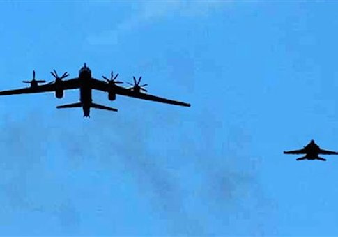 In this photo released by the U.S. Navy, an F/A-18 Hornet from aboard the aircraft carrier USS Nimitz, escorts a Russian Tupolev 95 Bear long rang bomber aircraft on Feb. 9, 2008