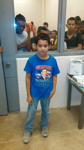 A young undocumented migrant boy from Honduras at a Texas holding facility. The boy, who wears an Obama 2008 t-shirt, came with thousands of other children from Central America over the past eight months believing that they will not be deported. Most of the children, who are looking for their parents or traveled as a family unit, are being sent to other long term facilities in the United States until relatives can be located. This photo was courtesy of a Border Patrol agent whose name was withheld to protect their identity. 