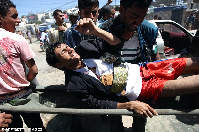 Stretcher bearers: Protesters carry an injured colleague to hospital 