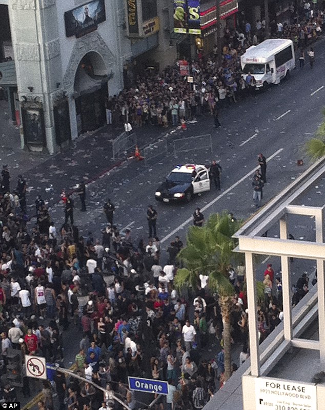 Police hold back the crowd that had gathered for the showing of a film about the Electric Daisy Carnival rave