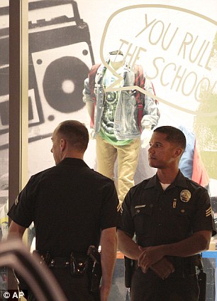 Los Angeles Police officers stand watch near the intersection of Hollywood Boulevard and Highland Avenue after an unruly crowd trying to attend an Electric Daisy Carnival concert film threw rocks and bottles at police cars in Los Angeles