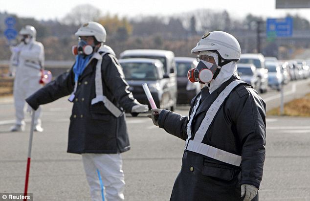 Scary scene: Police officers wearing respirators guide people evacuating the area around the plant