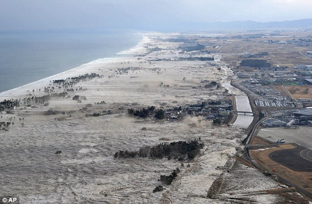 Terrifying: The tsunami slams into the shore line along Iwanuma in northern Japan after the 8.9 eathquake struck today