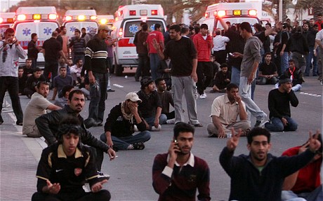 Bahraini protesters pray and sit in the street 