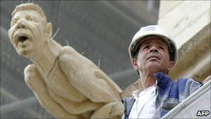 Ahmed Benzizine poses next to the gargoyle modelled on him at Lyon's St Jean cathedral