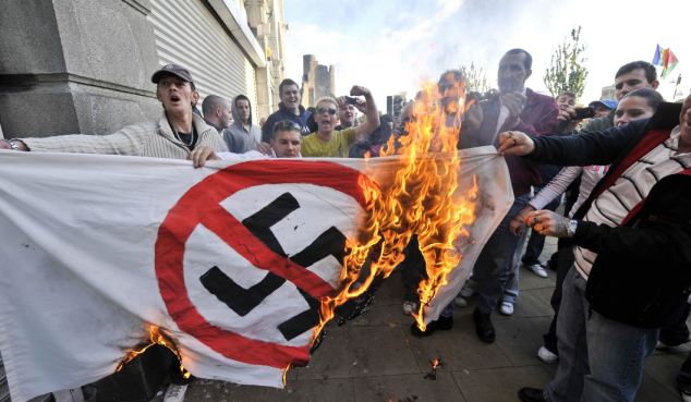 Welsh Defence League members burn an anti-Nazi flag in Swansea